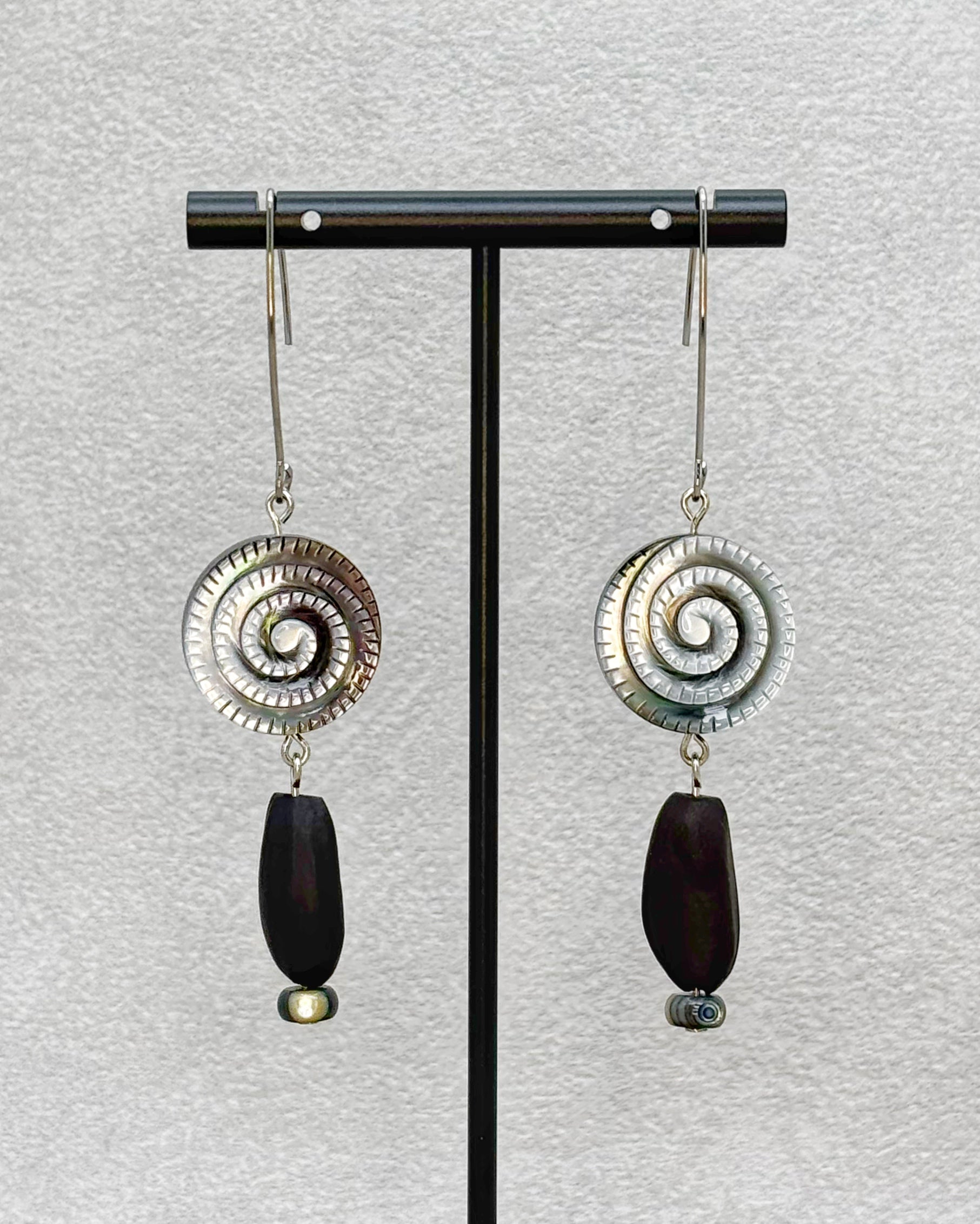 Black Lip Swirl Dangles featuring silver spiral tops with dark elongated beads and small round accents on silver hooks