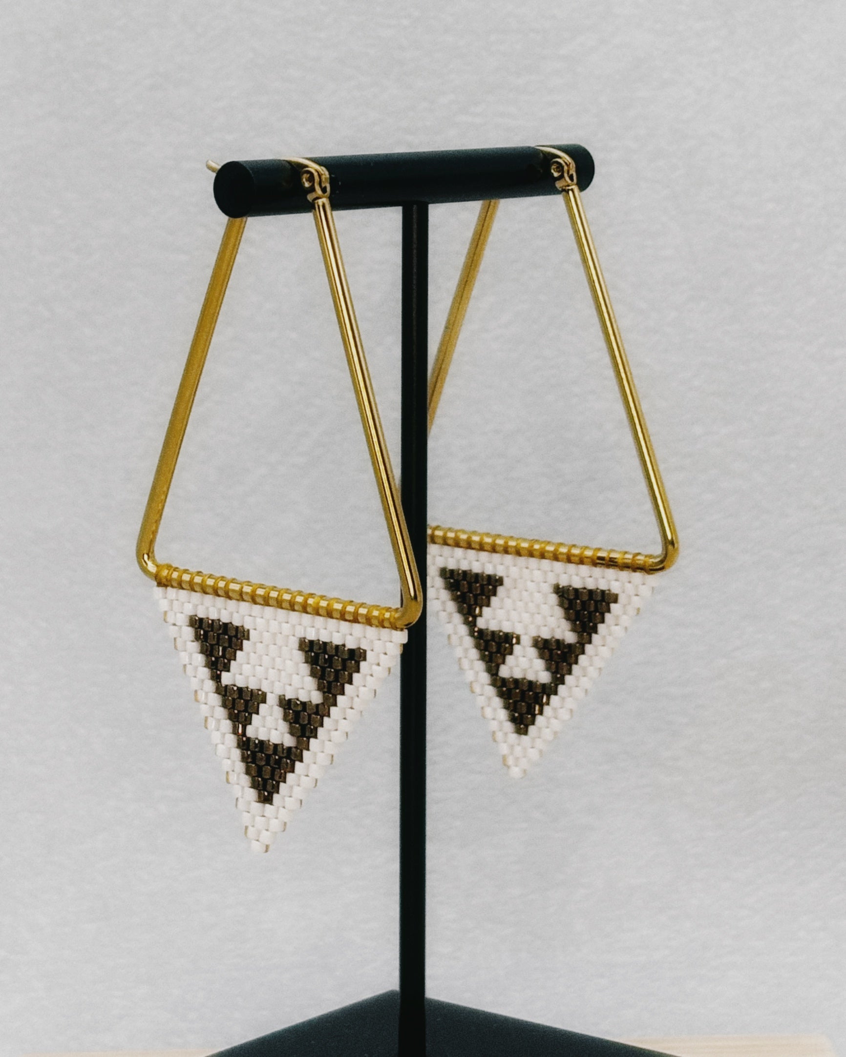 Medium Triangle Hoops featuring gold-tone triangular frames with black and white handmade beaded triangle accents