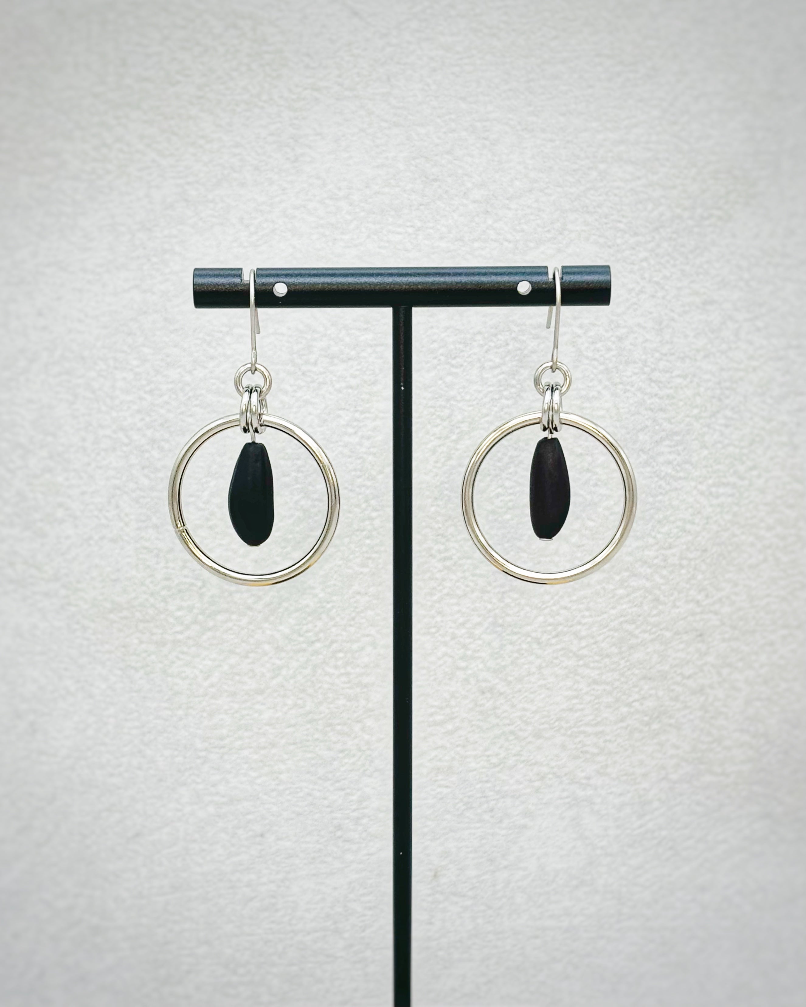 Pinenut Steel Dangles with polished silver hoops framing dark beaded pinenut-shaped accents on delicate hooks