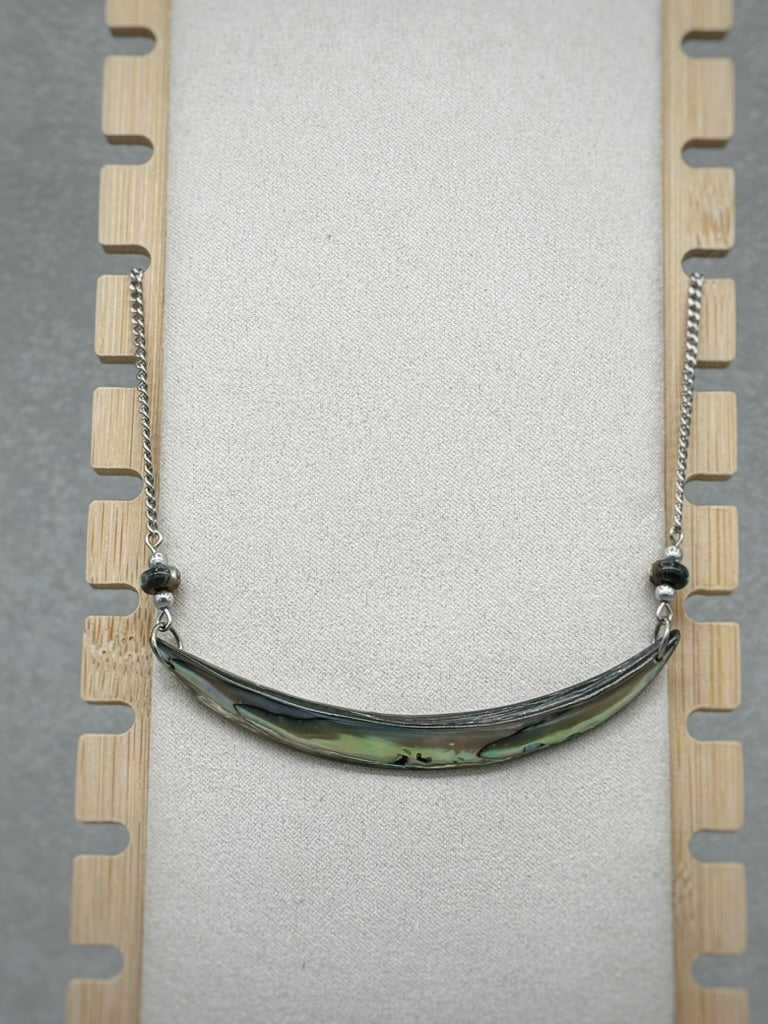 Abalone Lip Necklace featuring a polished shell centerpiece with iridescent green and blue hues on a silver chain