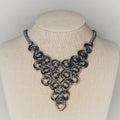 Steel Chainmail Triangle Necklace with geometric stainless steel swirls forming a polished triangular bib pendant gallery position 1