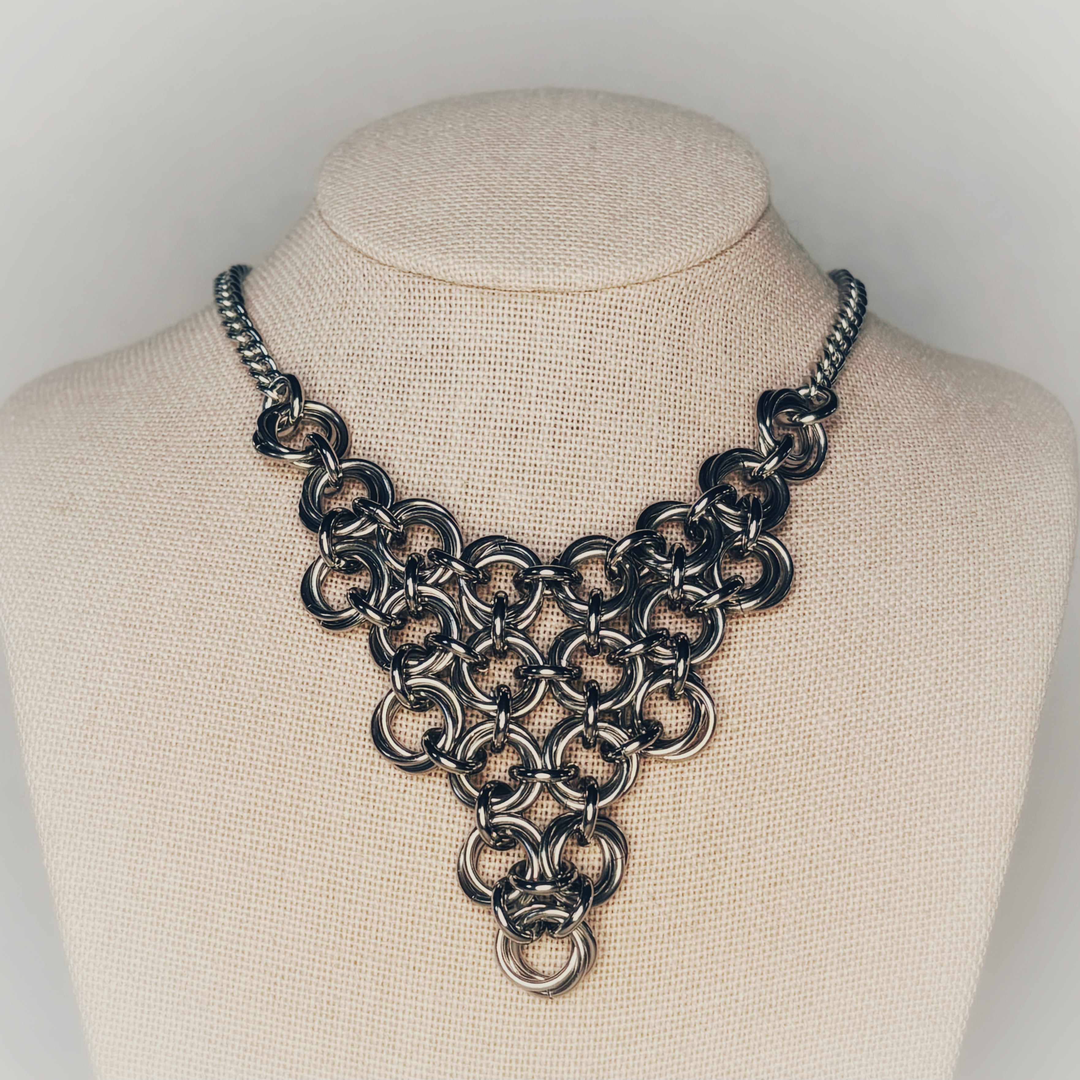 Steel Chainmail Triangle Necklace with geometric stainless steel swirls forming a polished triangular bib pendant gallery position 1