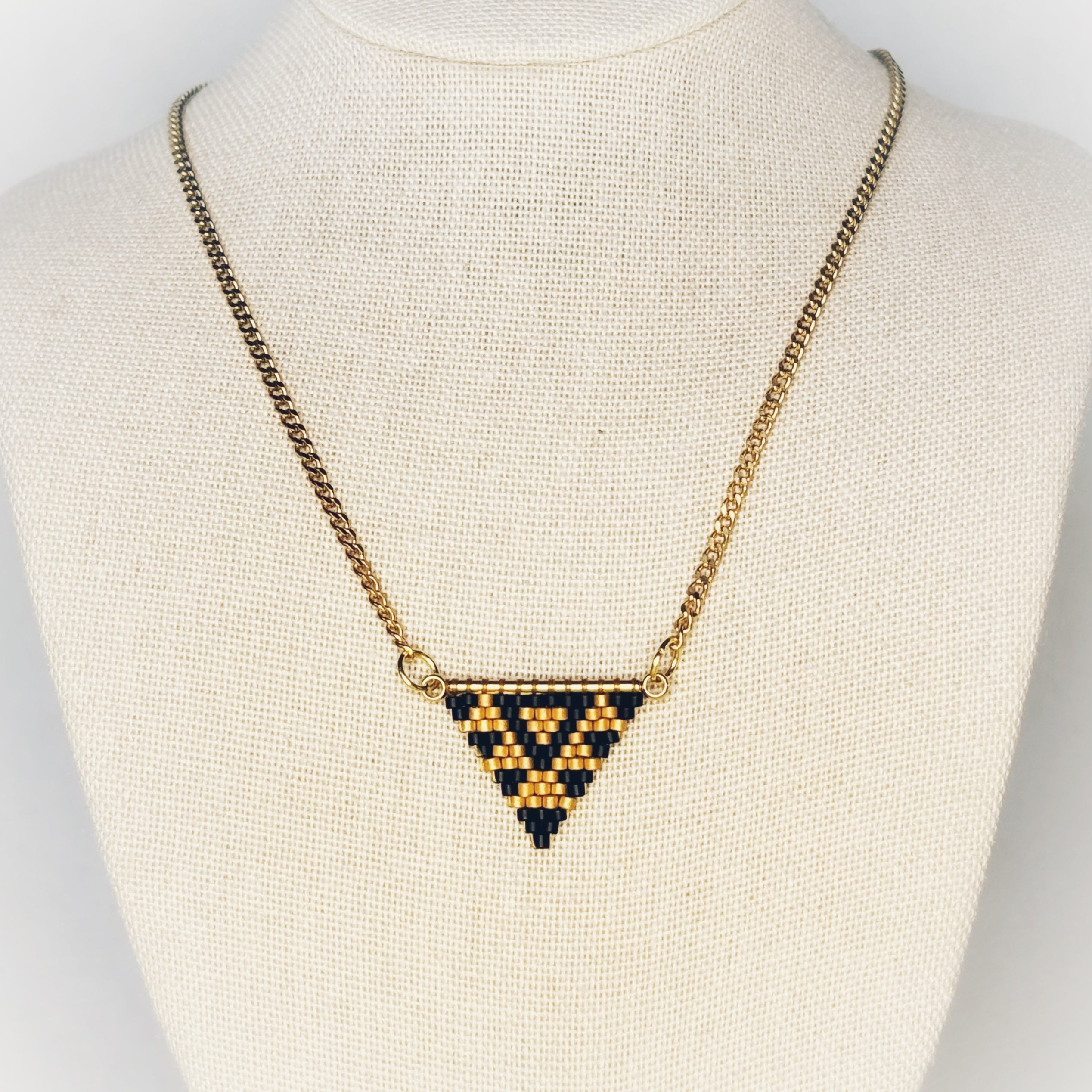 Black and Gold Goose Beaded Necklace featuring a geometric triangle pendant with matte black and gold basket pattern gallery position 1