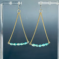 Turquoise Gold Chain Drops featuring delicate gold chains with curved row of faceted turquoise beads on clear display