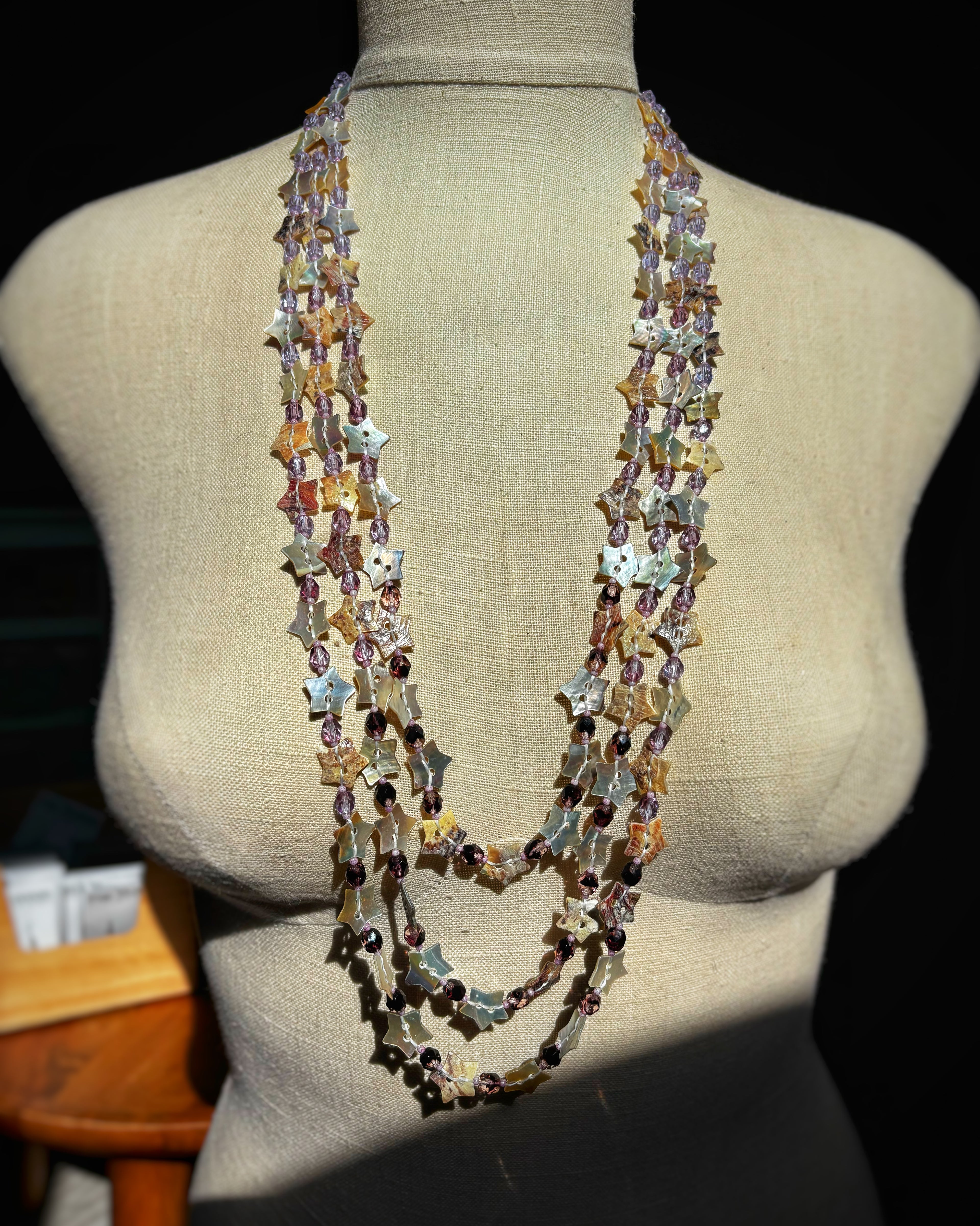 Three Strand Purple Abalone Star Button Necklace with layered iridescent star-shaped shell beads and small accent beads