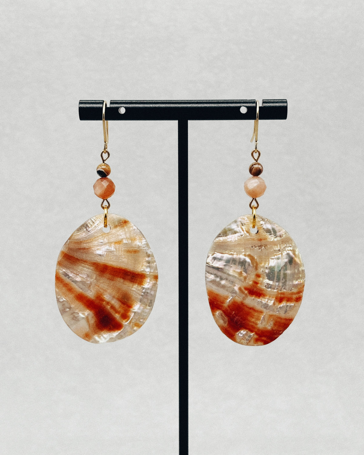Red Abalone Oval Dangles featuring translucent red and cream shell pendants with small beads and gold hooks