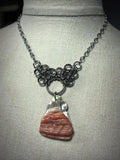 Steel and Abalone Necklace 2 featuring a unique abalone shell pendant with textured red and iridescent hues on steel chainmail
