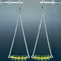 Olivine 5 Bead Silver Chain Drops with delicate silver chains and translucent olive green glass beads hanging on clear display stand