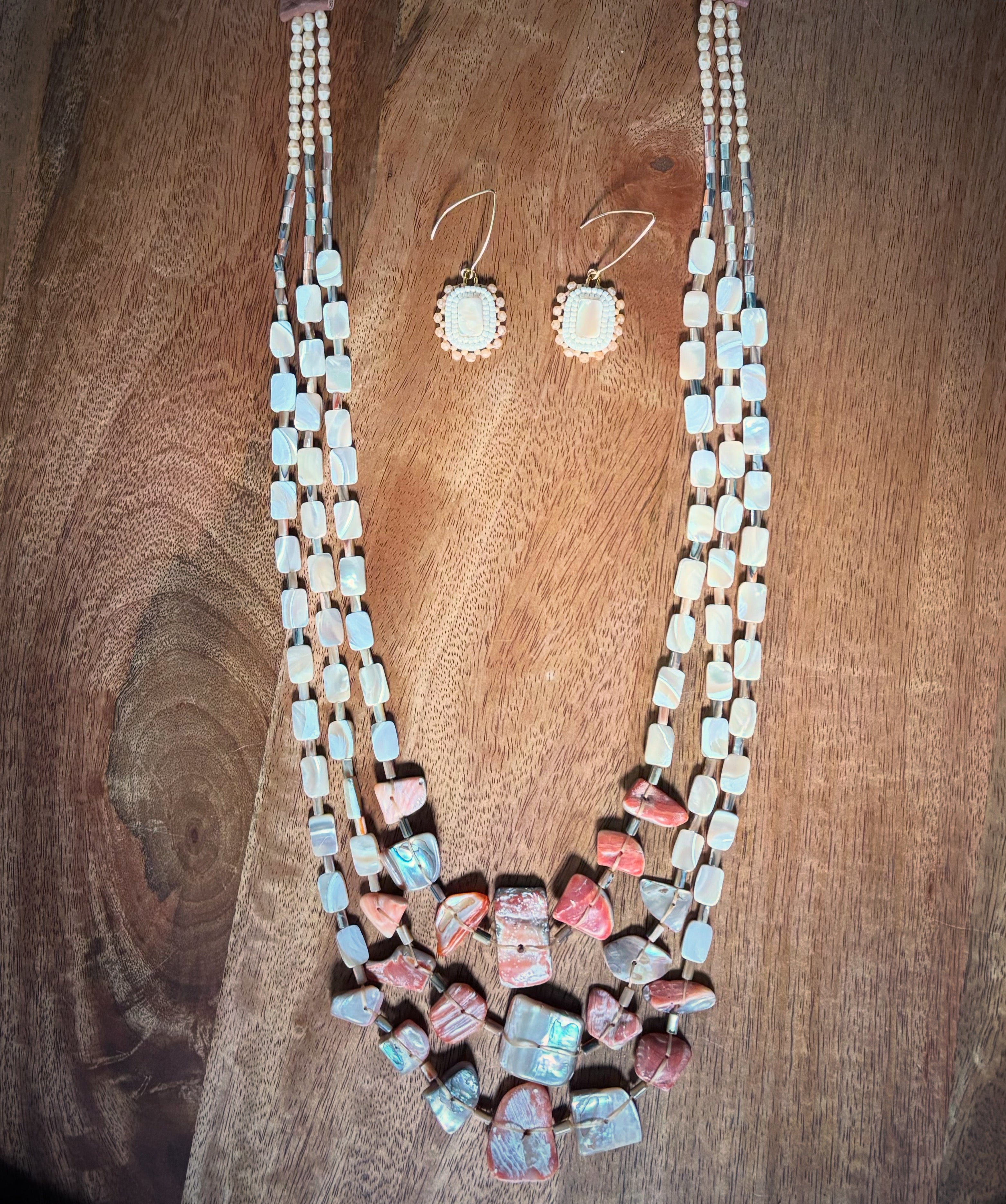 Necklace and earrings with colorful beads on a wooden surface