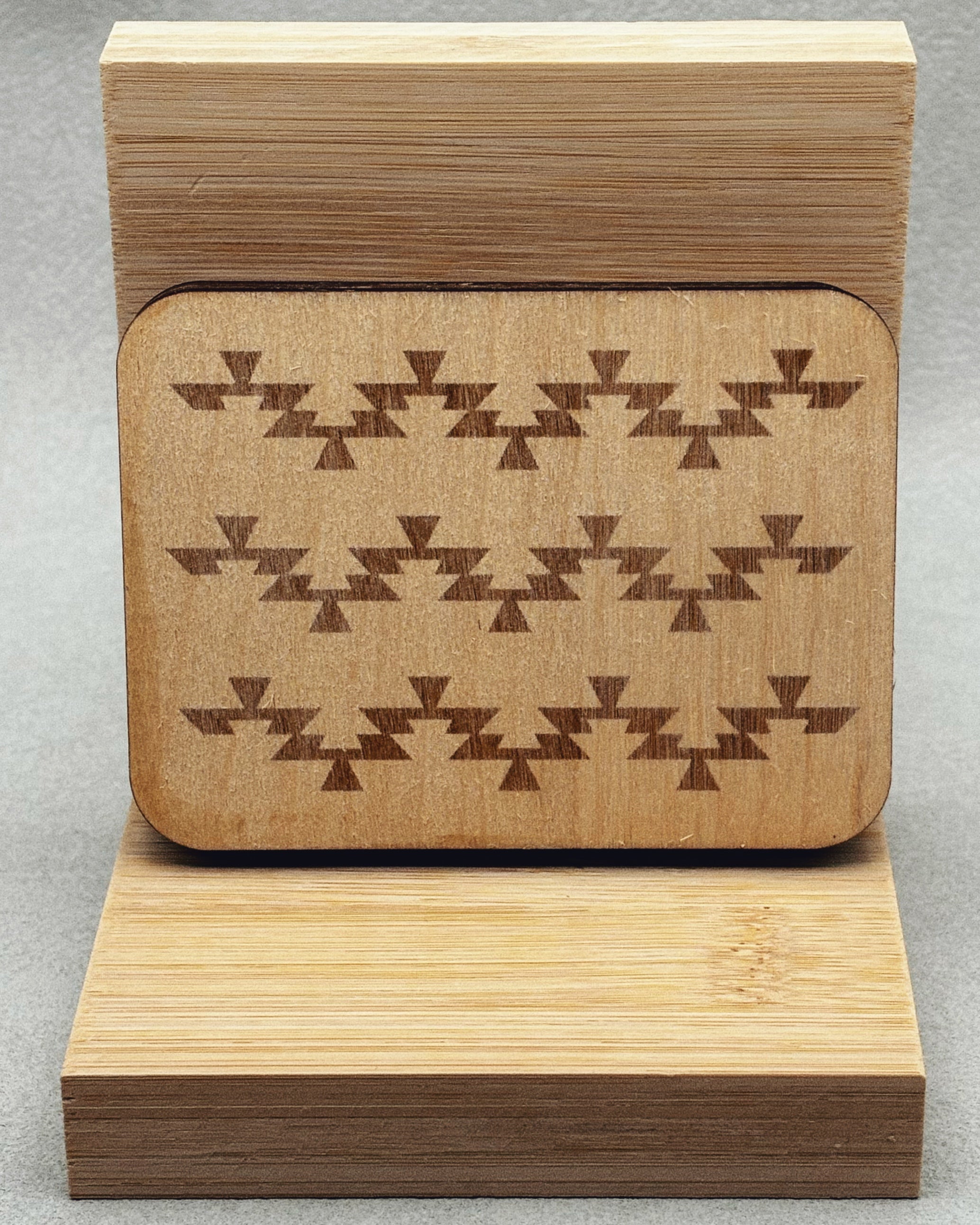 Needle Keepers wooden box with engraved dark geometric pattern on smooth light wood surface standing upright