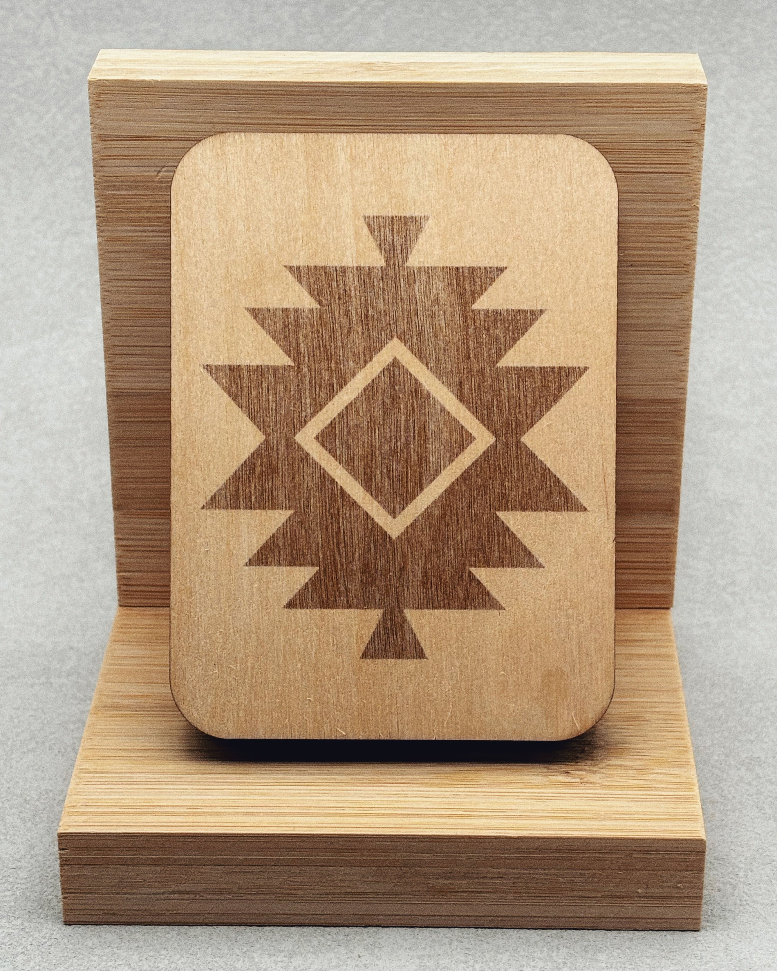 Needle Keepers wooden box with engraved southwestern geometric design on smooth light wood displayed on wooden stand