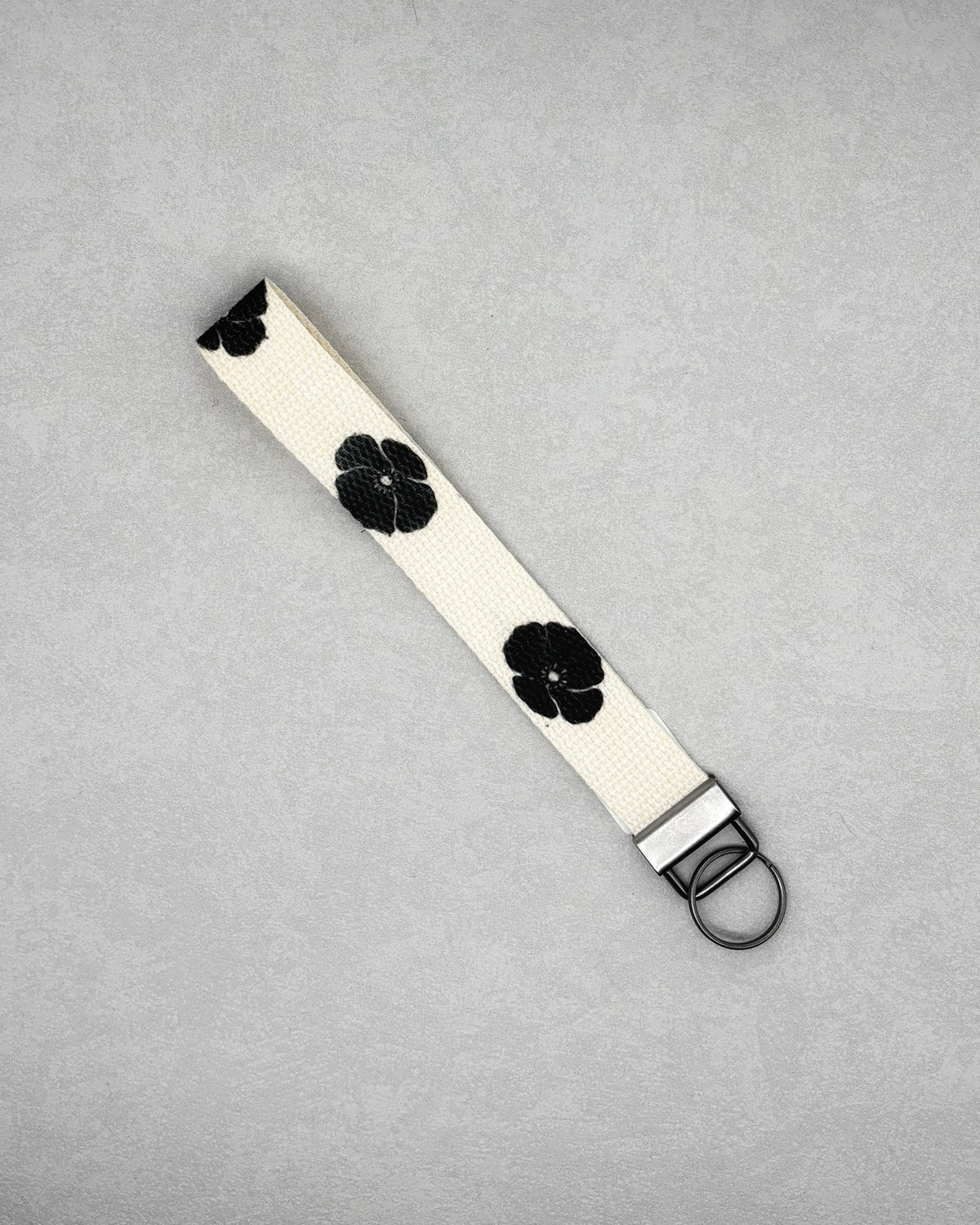 Wristlet Keychains cream wristlet with black flower pattern and metal key ring