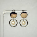 Pearl Silver Circle Studs featuring polished silver discs with dangling silver rings and centered pearl accents