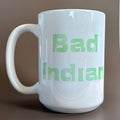 White ceramic 16 oz Bad Indian Mug Green with bold green text showcasing a powerful statement design