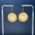 Handmade Two-Tone Tan Beaded Clamshells with tan and cream beads displayed on clear stand against dark background