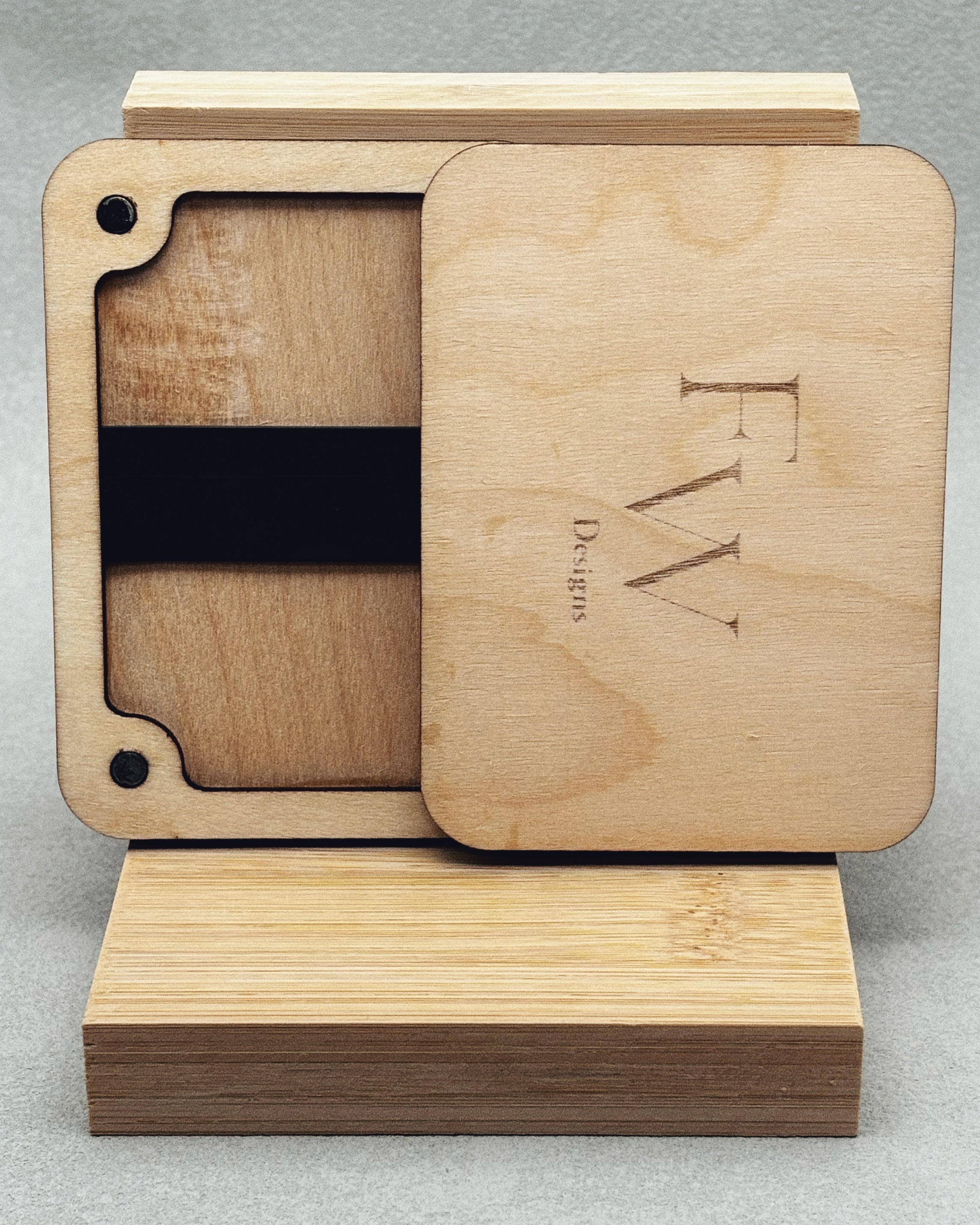Needle Keepers wooden box with sliding lid engraved FW Designs on smooth light wood displayed on bamboo stand