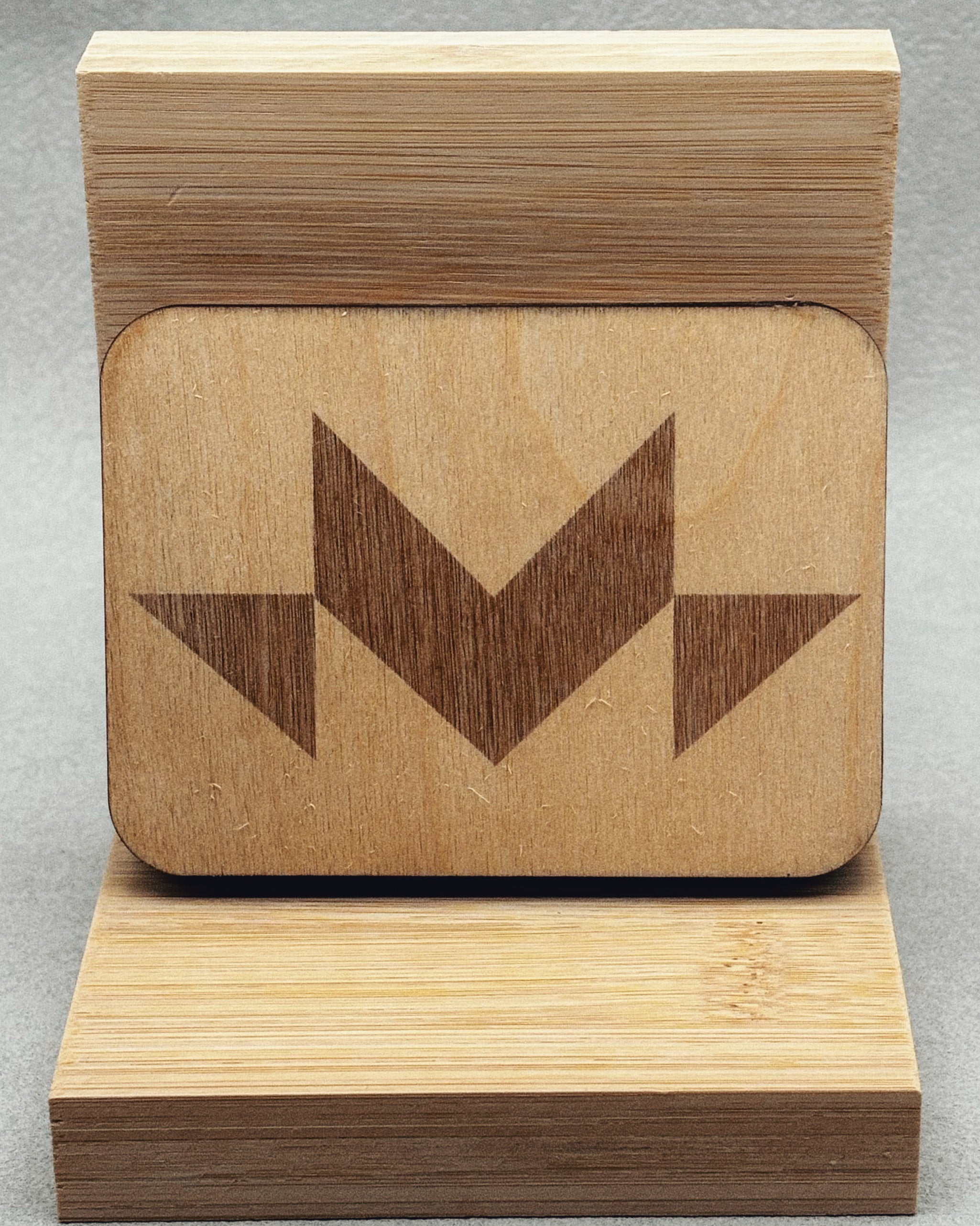 Needle Keepers wooden box featuring a simple dark geometric arrow design on smooth light wood surface