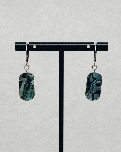 Abalone Oval Silver Huggie Dangles with iridescent green and blue shell charms on polished silver hoops