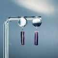 Wampum Silver Circle Studs with polished silver discs and hanging authentic purple wampum cylinder beads on clear stand