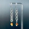 Silver Shaggy Dangles with Cedar Berries featuring handmade chainmail rings and natural bead accents on clear display stand