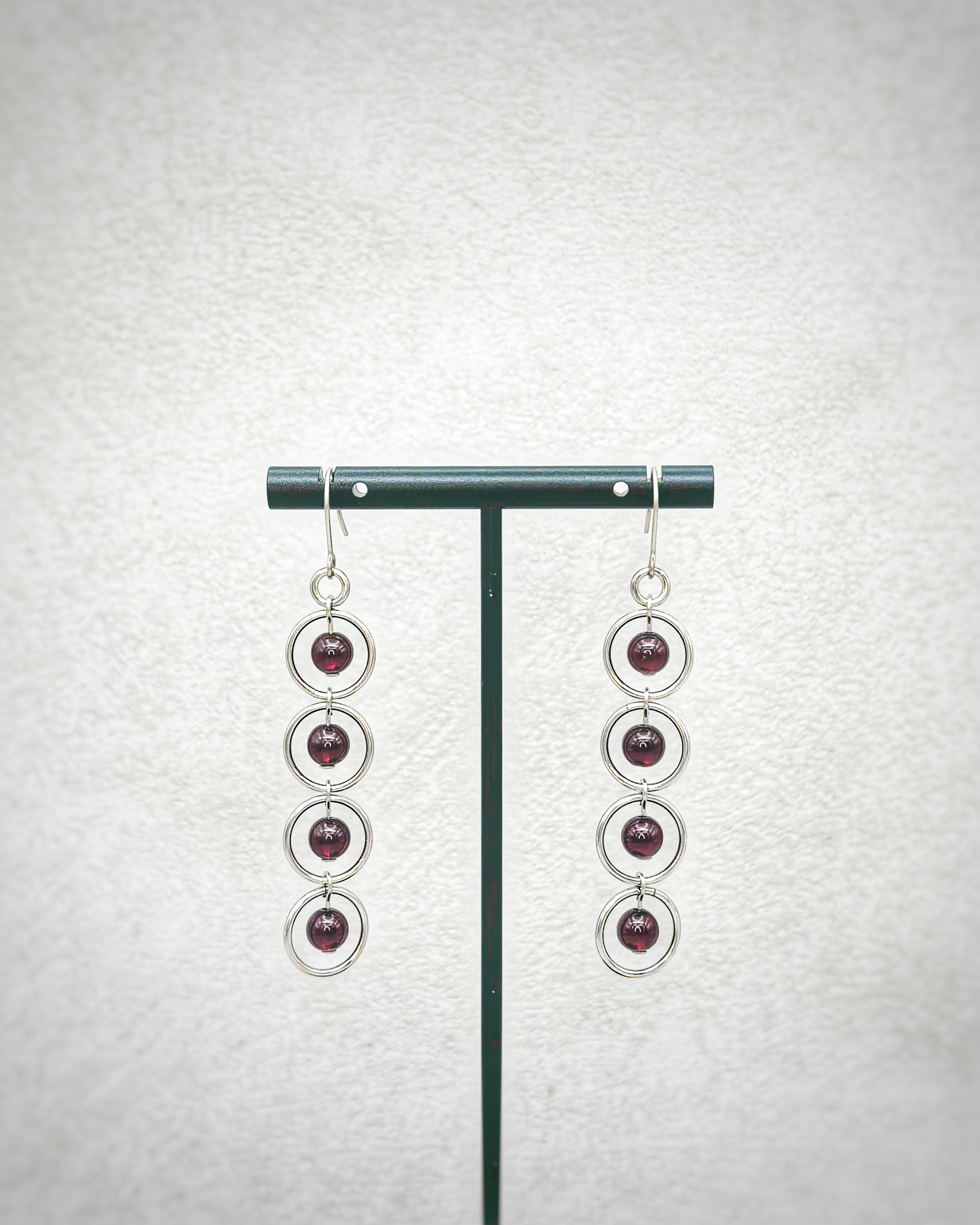 Garnet Silver Circle Dangles featuring four deep red garnet stones set within linked silver rings on hooks