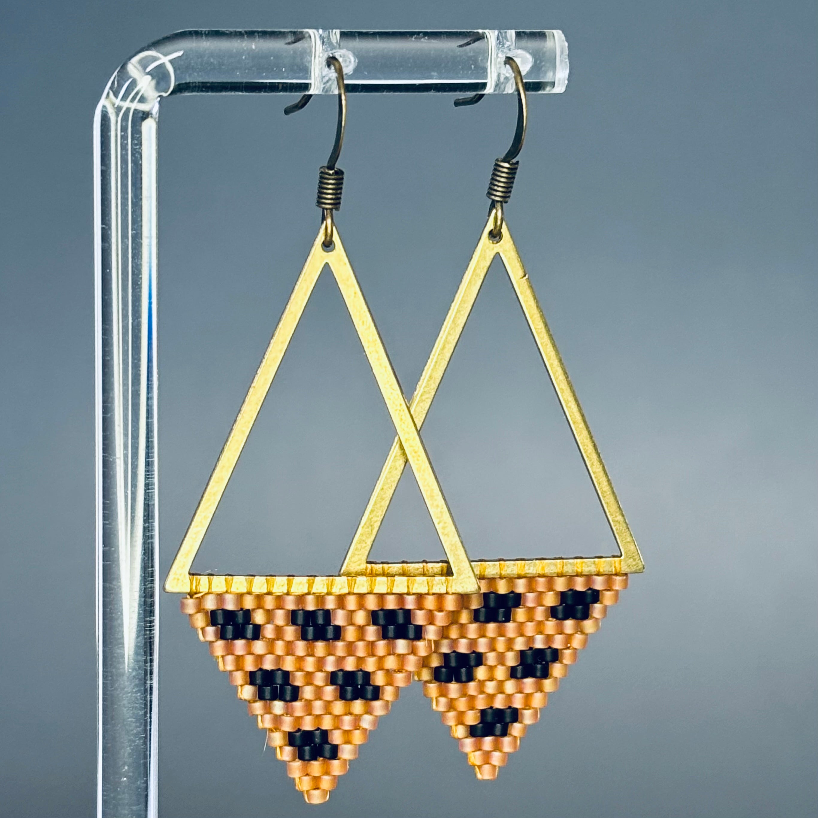 Bronze Triangle Dangles featuring open bronze triangular frames with beaded patterns in warm tones and black accents