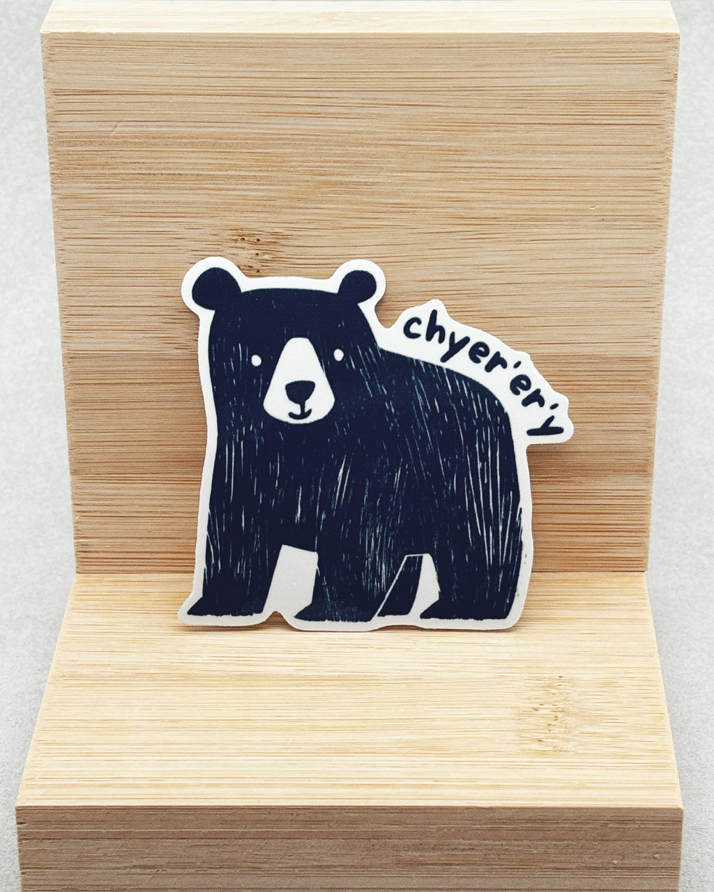 Yurok Vocabulary Stickers showing a hand-drawn black bear with white facial details and the word "chyerery" on light wood background