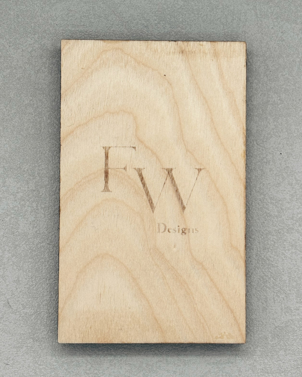 Wooden block with subtle "Fw Designs" branding engraved, used for packaging Scissor Keepers product display.