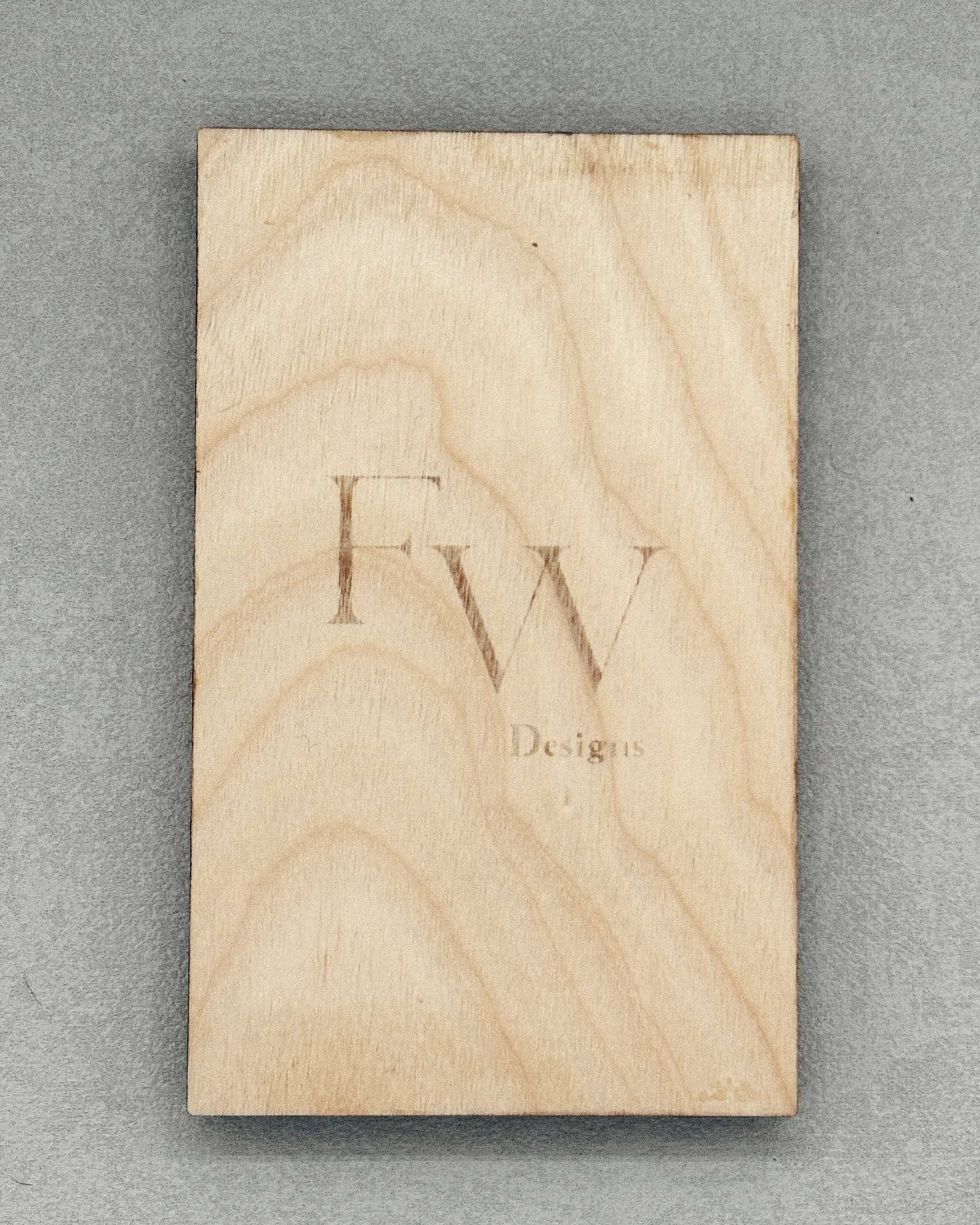 Wooden block with subtle "Fw Designs" branding engraved, used for packaging Scissor Keepers product display.