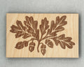 Scissor Keepers with engraved oak leaves and acorns design on smooth light wood background