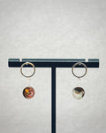 Faceted Abalone Silver Open Circle Studs featuring iridescent abalone drops on silver open circles on a display stand