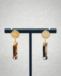 Abalone Cylinder Gold Circle Studs with polished gold discs and natural abalone cylinder drops on a black stand display