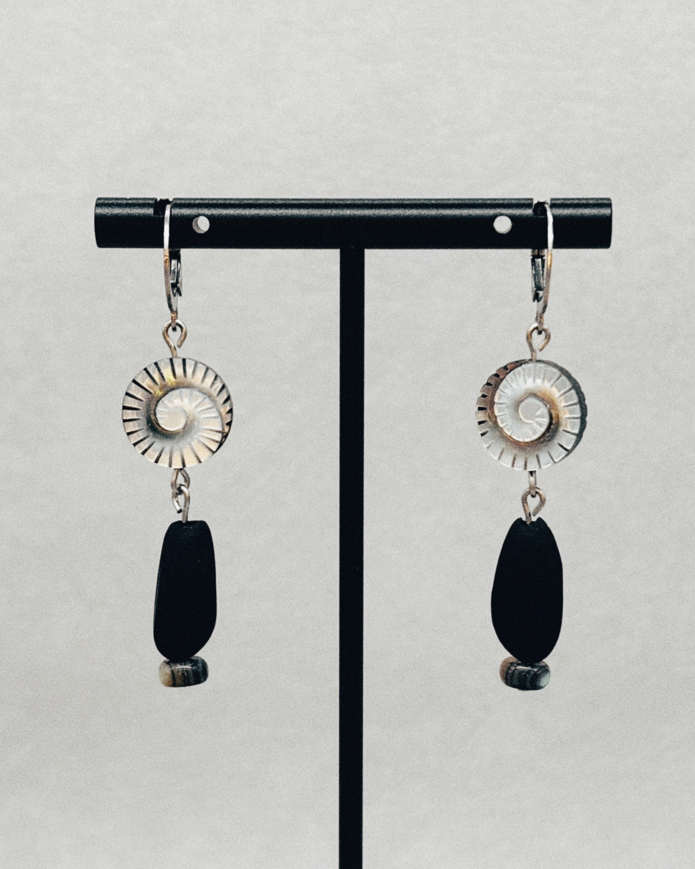 Black Lip Swirl Dangles featuring spiral shell details with elongated black stone and small bead accents, handmade indigenous jewelry.