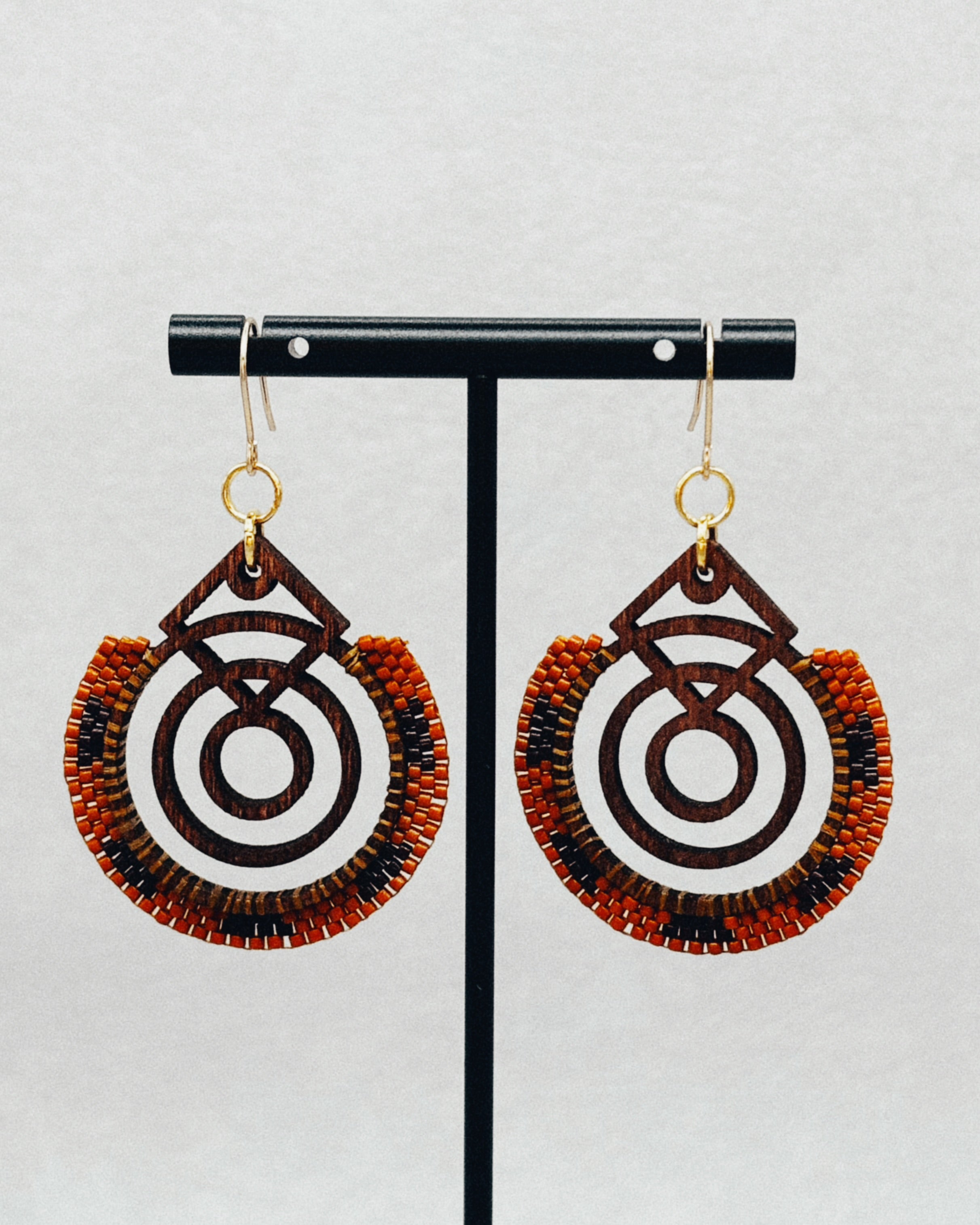 Walnut Brick Stitch Hoop Dangles featuring circular wood design with brown, orange, and black handmade beaded accents