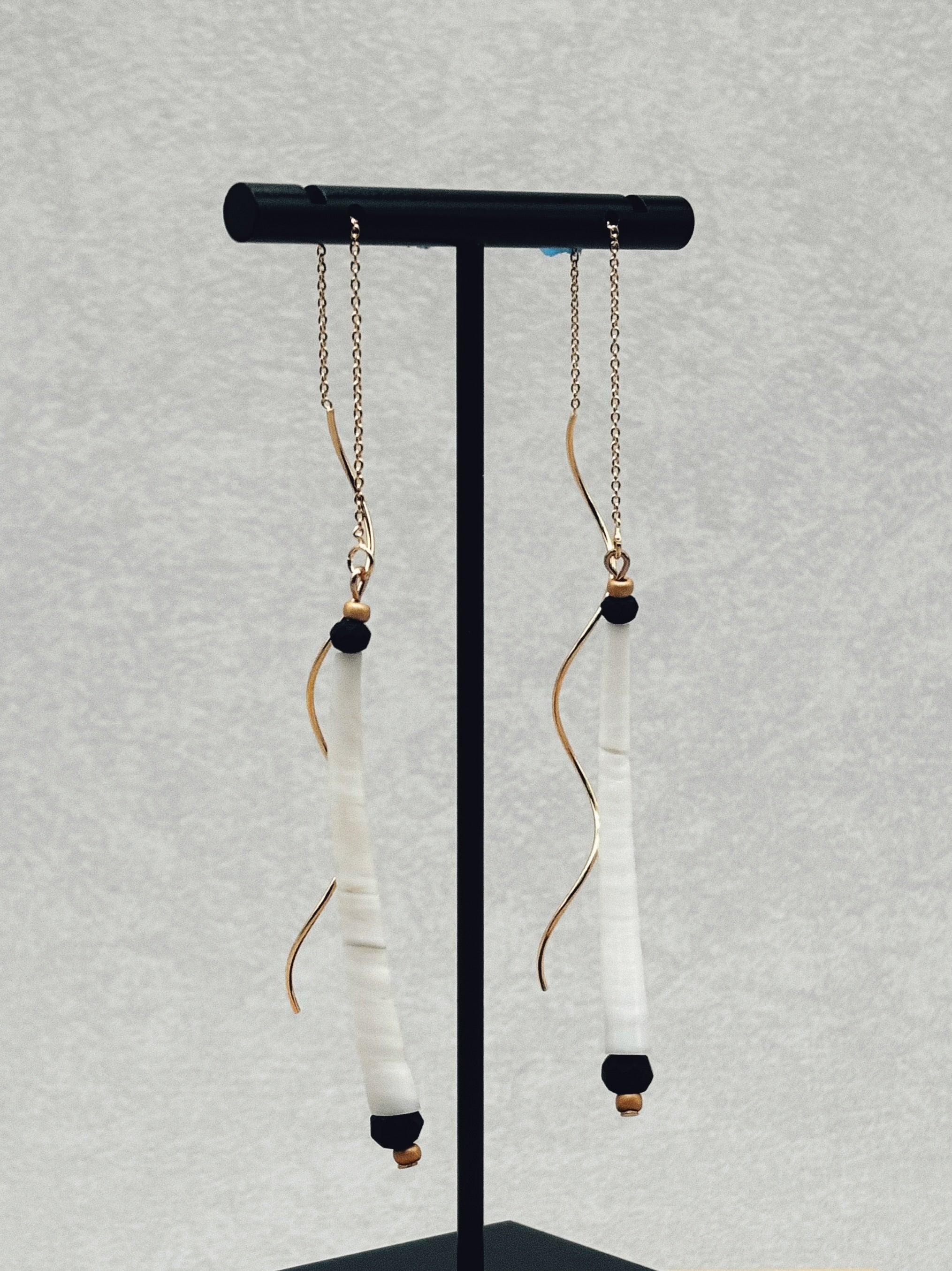 Black and Gold Dentalium Drops hanging delicate gold chains with white dentalium and black bead accents on display stand