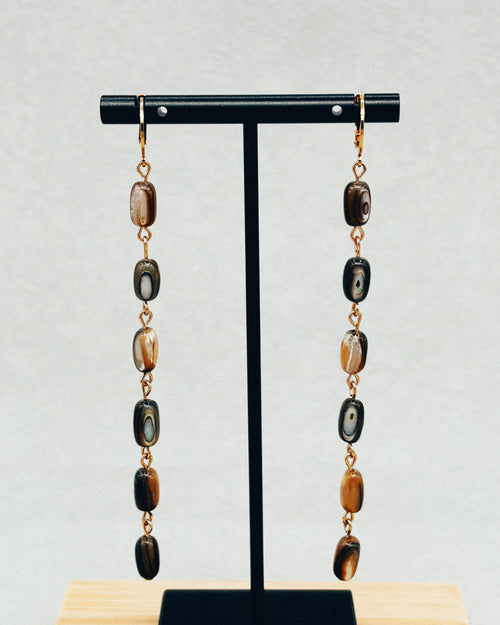 Abalone Nugget Dangles with iridescent stone beads displayed on a black jewelry stand